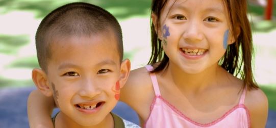 Two children smiling with face paint on their cheeks